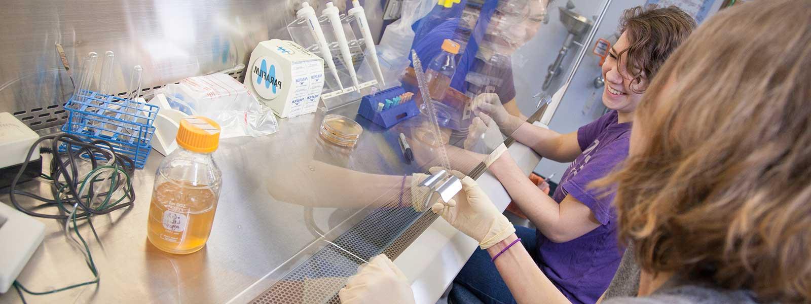 student smiles while working in micro生物学 lab