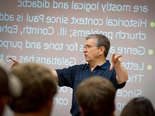 Professor in front of projector teaching class