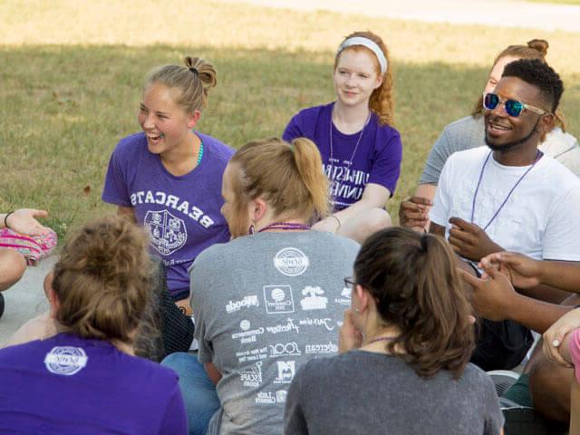 SBU students sitting outside laughing and talking